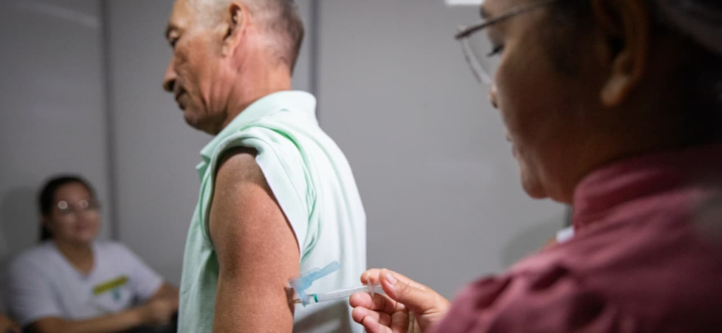 Profissional de saúde aplicando vacina contra dengue