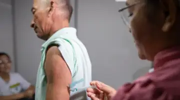 Profissional de saúde aplicando vacina contra dengue