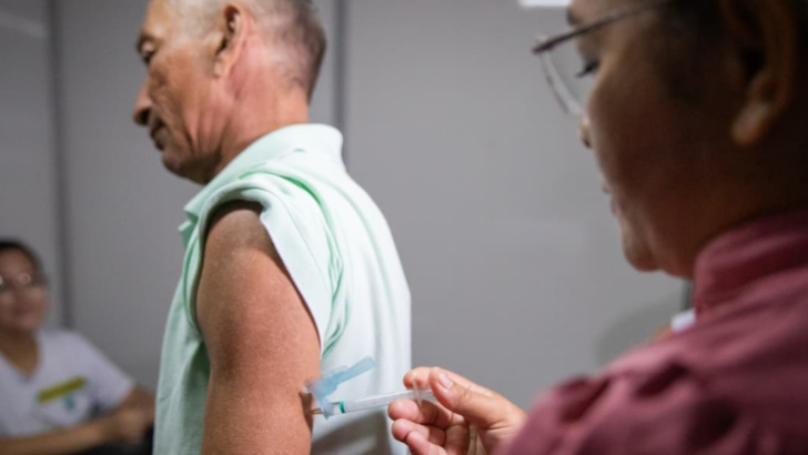 Profissional de saúde aplicando vacina contra dengue